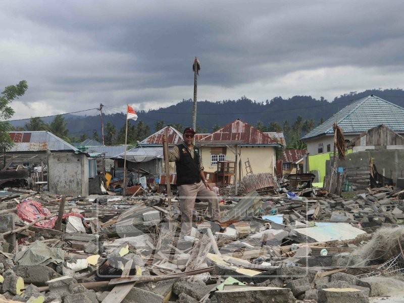 Mohd Zin berada di antara timbunan runtuhan bangunan di kampung Loli Dondo.