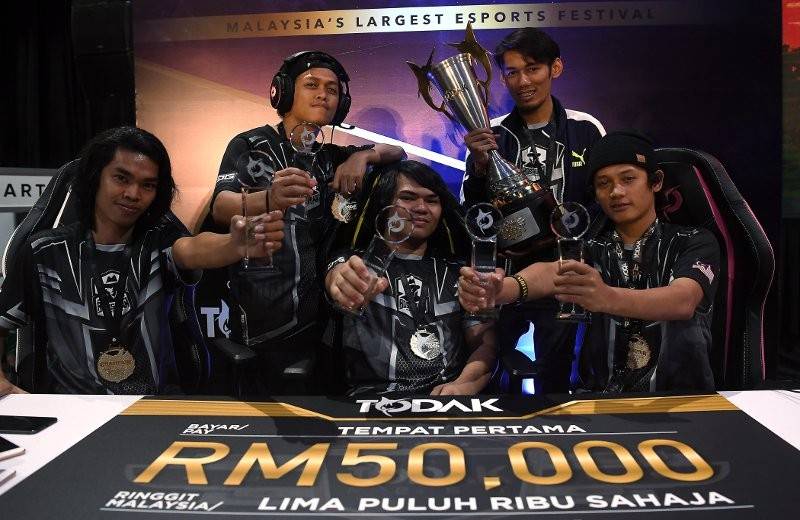 Pasukan Bosskurr bergambar bersama piala dan replika cek bernilai RM50,000 selepas menjuarai Kejohanan Todak Cup Mobile Legends sempena Festival Komuniti E-Sport Terbesar Malaysia Todak Fest di Pusat Pameran Midvalley, semalam. - Foto Bernama