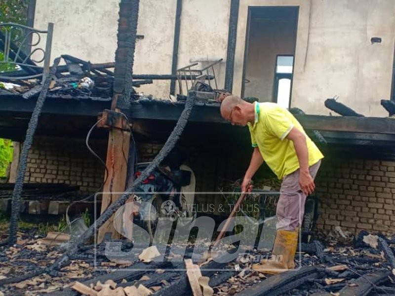 Syed Uluwi memeriksa rumahnya yang hangus, petang tadi.