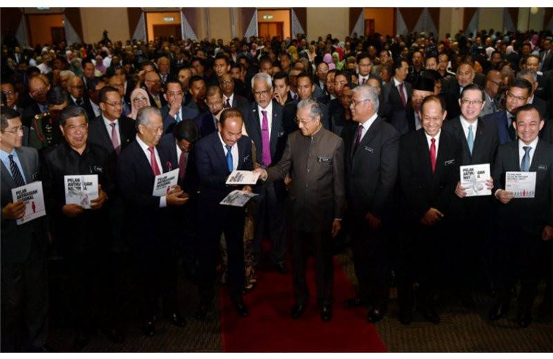 Mahathir (tengah) melihat Pelan Antirasuah Nasional (NACP) 2019-2023 pada majlis pelancaran pelan itu di Pusat Konvensyen Antarabangsa Putrajaya (PICC) hari ini. - Foto Bernama