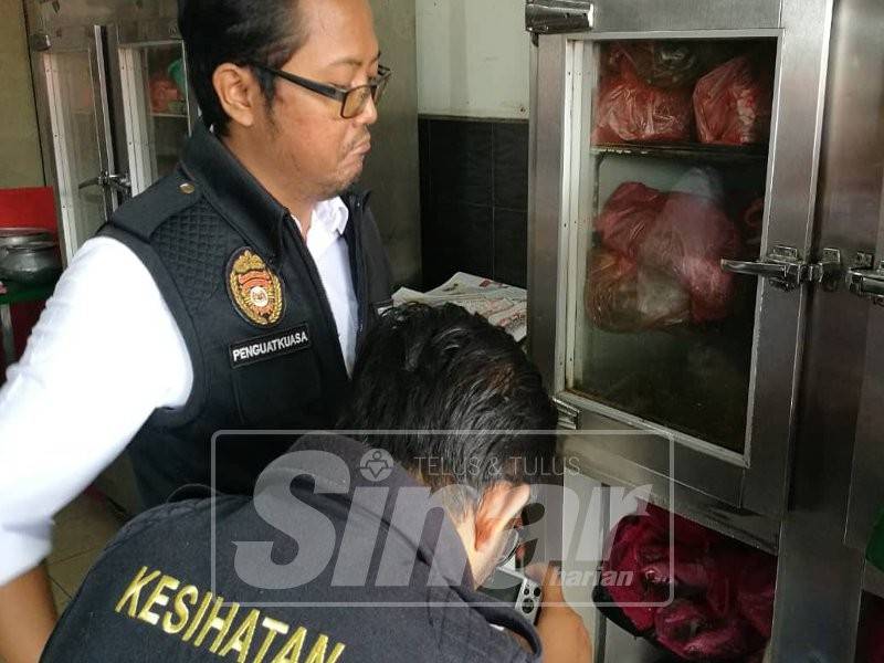 Anggota Penguatkuasa Pejabat Kesihatan, memeriksa peti sejuk beku sebuah restoran ketika operasi pemeriksaan halal di restoran di daerah Pontian, hari ini.
