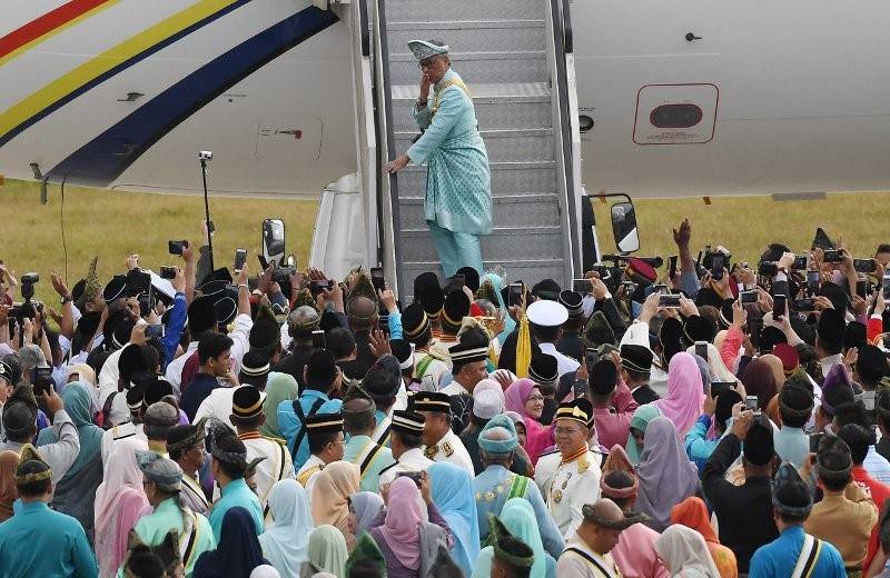 Al-Sultan Abdullah memberi kucupan kasih sayang kepada rakyat jelata yang hadir memberi penghormatan dan mengucap selamat berangkat ke Istiadat Melafaz dan Menandatangani Surat Sumpah Jawatan Sebagai Seri Paduka Baginda Yang di-Pertuan Agong Ke-XVI di Istana Negara, di Pekarangan Pergerakan Udara, Pangkalan Udara Kuantan, hari ini. - Foto Bernama