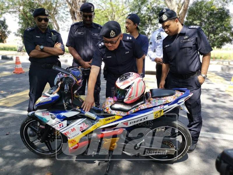 Seong Lim memeriksa sebuah motosikal yang melakukan kesalahan mengubahsuai kenderaan.