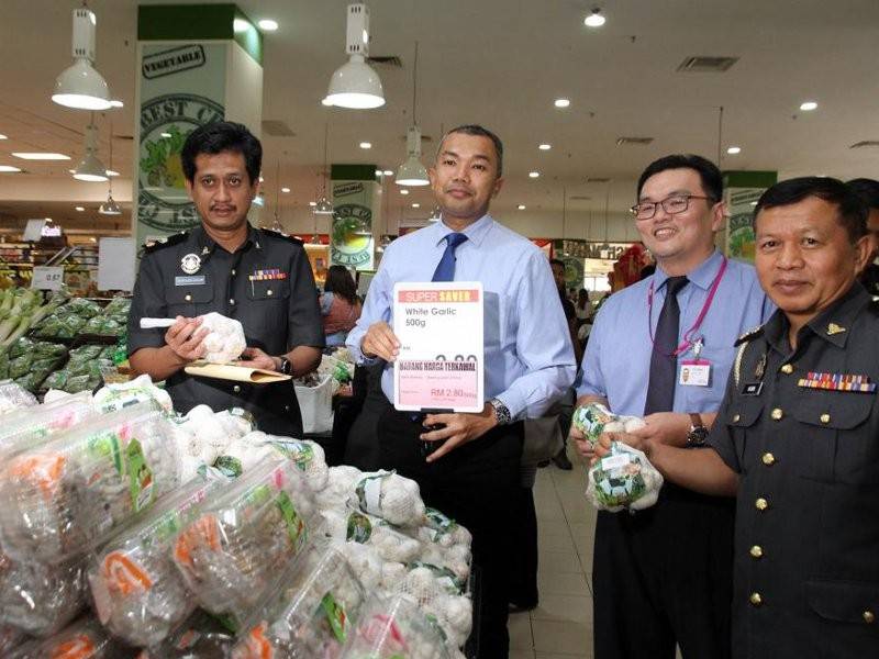 Saifullizan (dua, kiri) menunjukkan bawang putih yang merupakan salah satu barangan kawalan sempena musim perayaan kali ini. Foto: Bernama