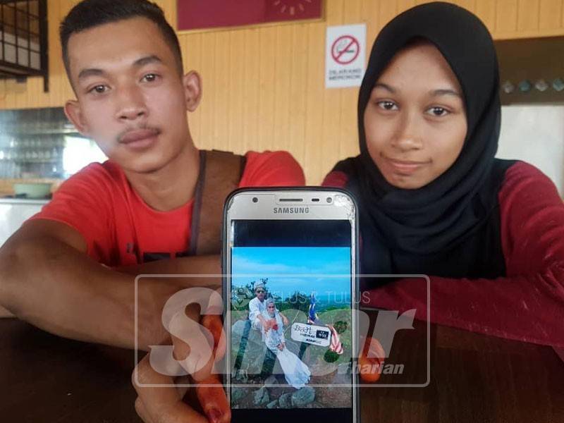 Mohd Zizi dan Nabila Akma menunjukkan foto mereka berbusana pengantin di atas Bukit Harimau Menangis, Kemasik yang tular di media sosial.