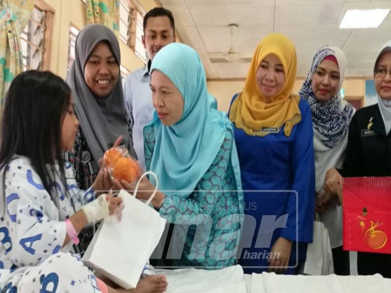 Sharifah Norhayati menyampaikan cenderahati kepada kanak-kanak sewaktu beramahmesra dengan pesakit serta petugas di wad kanak-kanak Hospital Hulu Terengganu sempena Tahun Baharu Cina.
