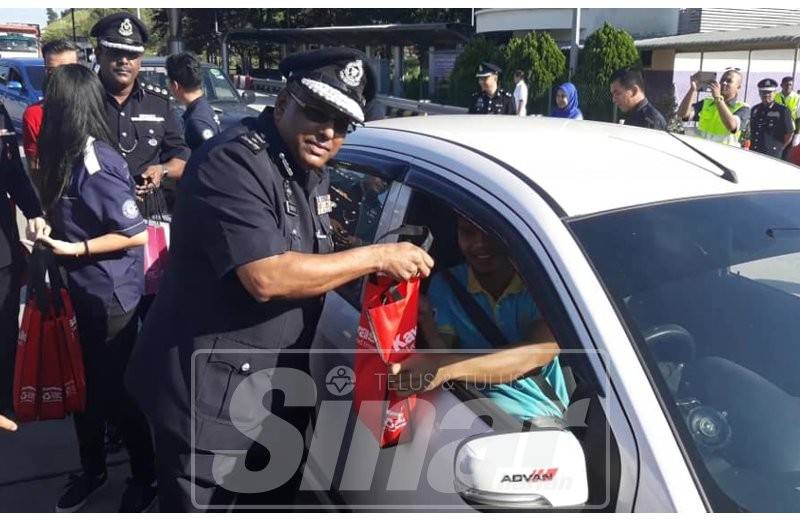 Kumaran menyampaikan kit pemanduan cermat di Plaza Tol Bukit Jelutong, Lebuhraya Guthrie, hari ini.