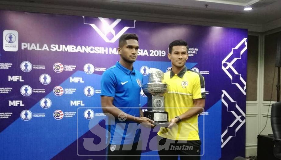 Harris (kiri) memegang Piala Sumbangsih bersama Shahrul pada sidang media berkenaan