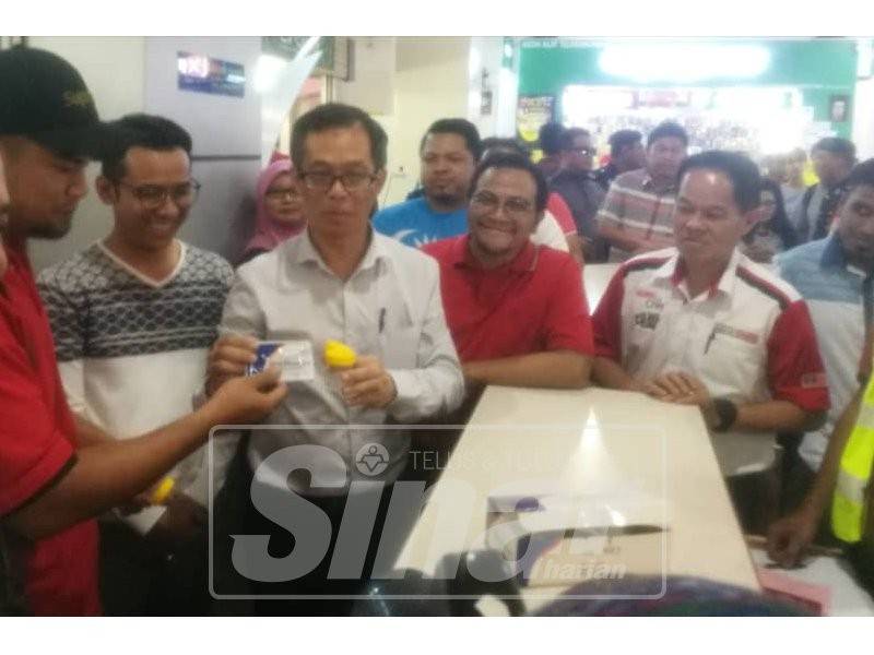 Chee Leong (empat, kanan) menyerahkan kit ujian saringan air kencing kepada seorang pemandu pada operasi itu yang dijalankan di Melaka Sentral, di sini, tadi.