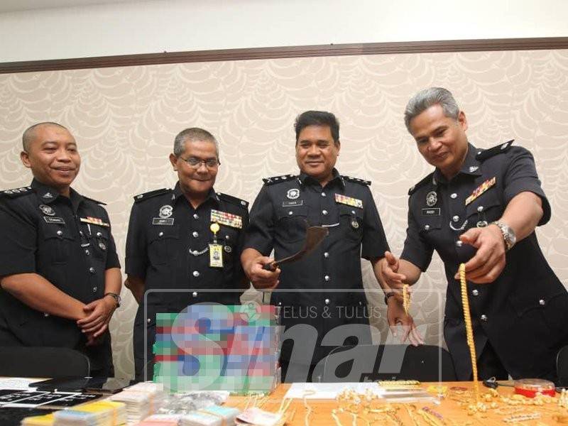 Yahya (dua, kanan) bersama pegawainya menunjukkan kejayaan polis menumpaskan kegiatan pecah kedai telekomunikasi di tiga daerah di Perak, hari ini.