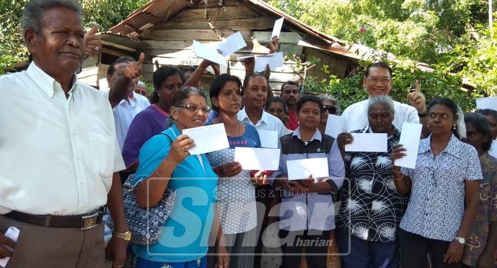 Kula Segaran (tengah) bersama sebahagian penduduk Kampung Tai Lee, Buntong, di sini, selepas menyerahkan bantuan bencana.