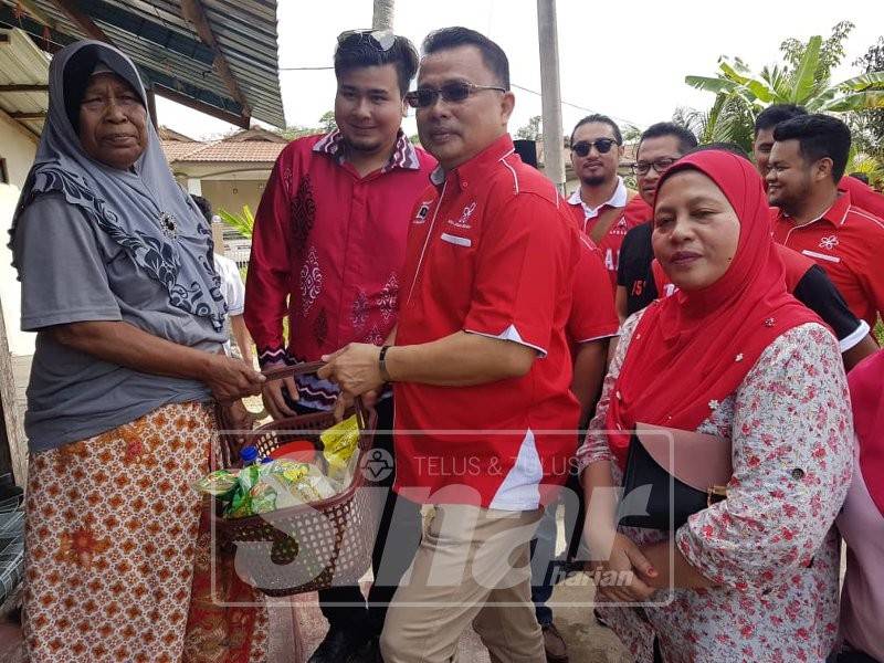 Wan Marzuki (dua, kanan) menyampaikan bantuan barangan keperluan makanan kepada ibu tunggal, Zalma Hamzah, 57, yang menjaga seorang anak orang kurang upaya pada Program Jalinan Kasih hari ini.