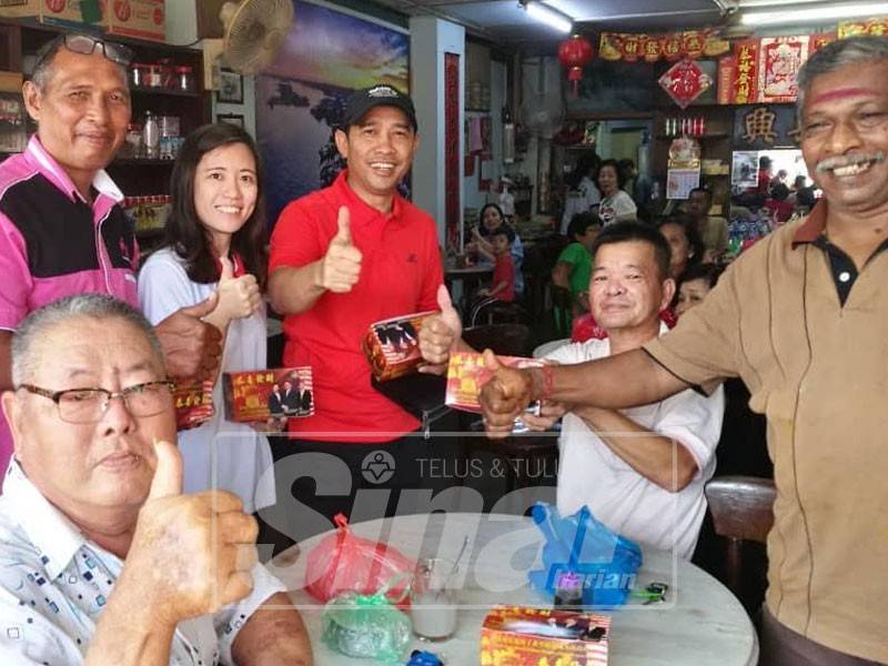 Abdul Yunus (tengah) teruja menyampaikan sumbangan kotak limau mandarin kepada penduduk Pekan Kuala Kurau tanpa mengira bangsa dan agama hari ini.