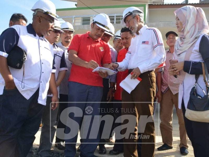 Raja Kamarul Bahrin (dua, kanan) ketika melawat tapak perumahan RIR di Santong, hari ini.