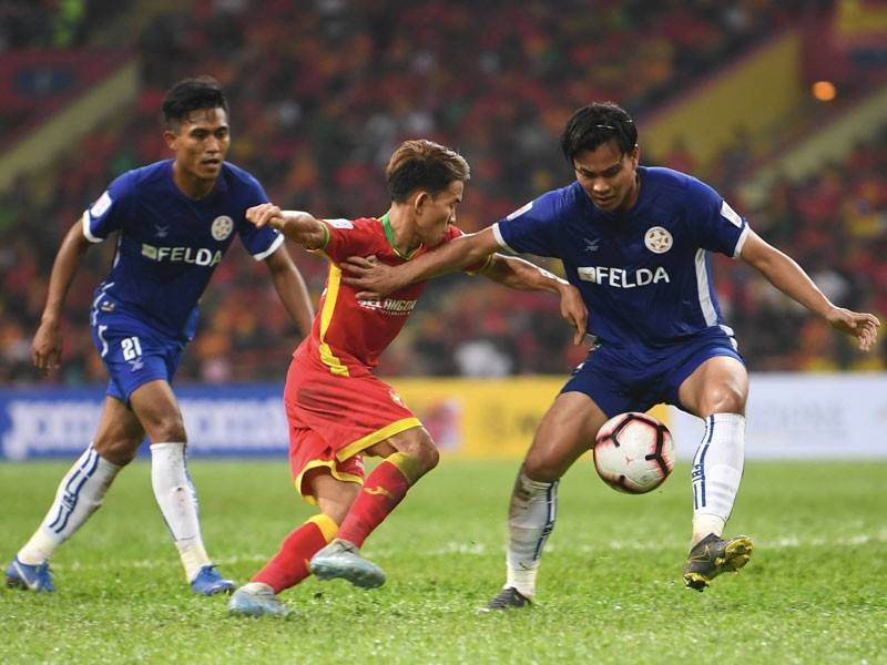 Pemain Selangor Mohd Faiz Mohd Nasir (tengah) diasak oleh dua pemain Felda United FC Mohamad Arif Fadzilah Abu Bakar (kanan) dan Jasazrin Jamaludin pada perlawanan Liga Super 2019 di Stadium Shah Alam malam ini. - Foto Bernama