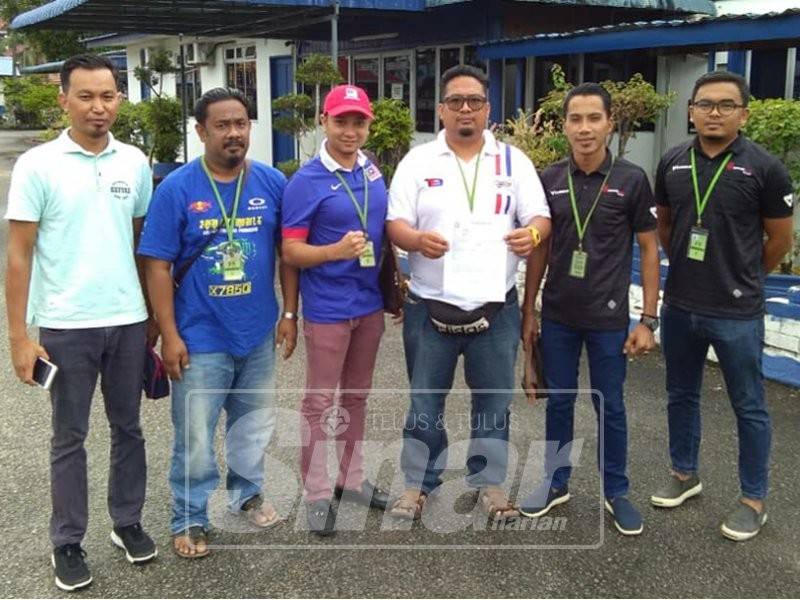 Mohd Sufyan Tsauri (tiga, kanan) dan bersama barisan Pemuda Umno Bahagian Hulu Terengganu menunjukkan salinan laporan polis di pekarangan IPD Hulu Terengganu, di Kuala Berang, kelmarin.