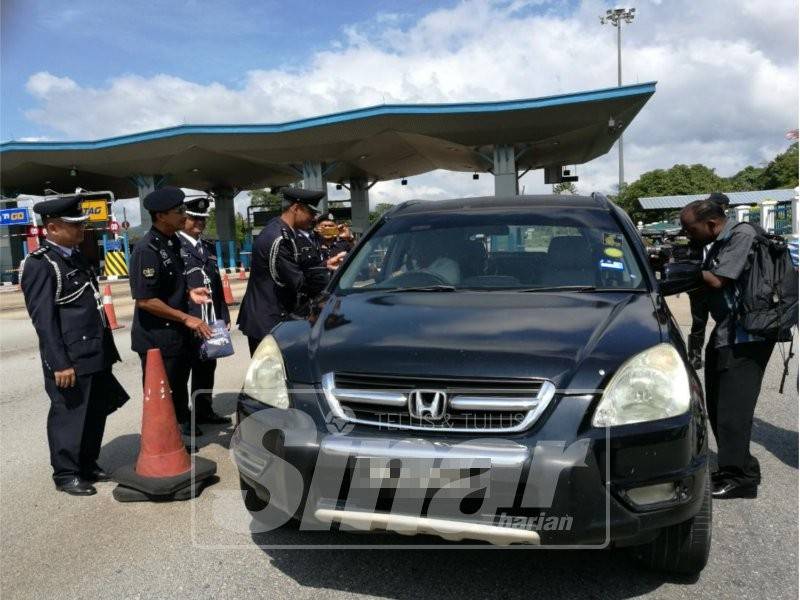 Ahmad Ridha memberi risalah keselamatan jalan raya dan beramah mesra bersama pengguna jalan raya sempena Pelancaran Ops Selamat Peringkat Daerah Kuantan di Plaza Tol Gambang di sini, hari ini.
