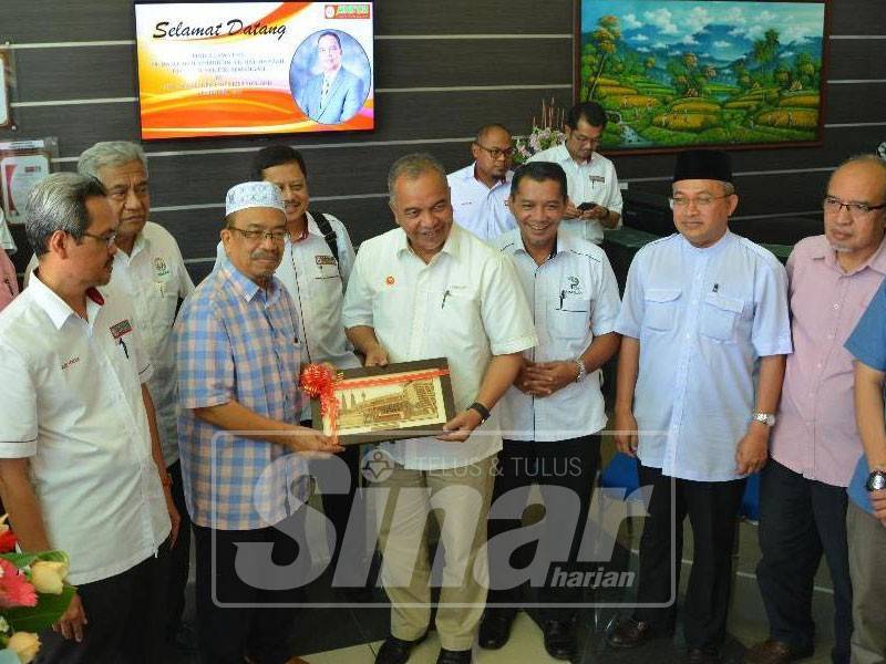 Phahrolrazi (dua, kiri) menyerahkan cenderahati kepada Amiruddin (empat, kanan) selepas melawat kilang Malaysian NPK Fertilizer Sdn Bhd.