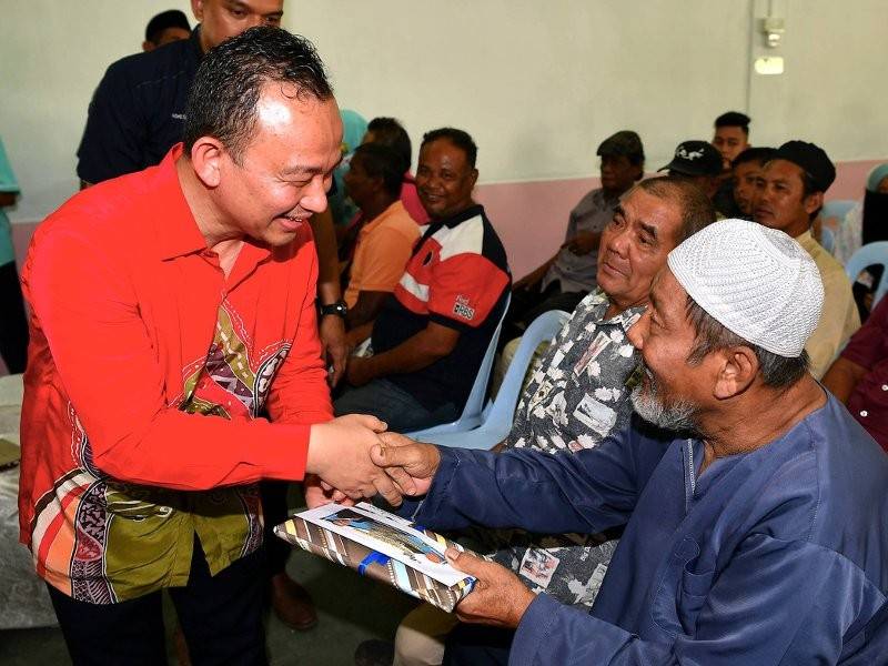 Menteri Pendidikan Dr Maszlee Malik (kiri) menyampaikan sumbangan kepada warga emas Ibrahim Senin pada Majlis Sirih Pulang ke Gagang di Dewan Raya Kampung Skudai Kiri hari ini. Foto: Bernama