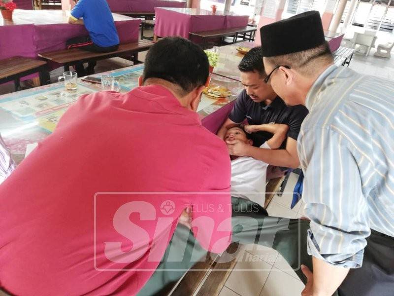 Abd Aziz (kanan) meriba dan mengurut anak muridnya perlahan-lahan sambil dibantu oleh guru-guru yang lain.
