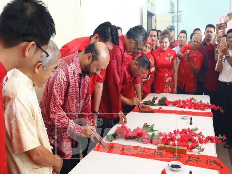 Mukhriz (tiga, kiri) menyempurnakan ayat terakhir kaligrafi Cina sempena sambutan Tahun Baharu Cina.
