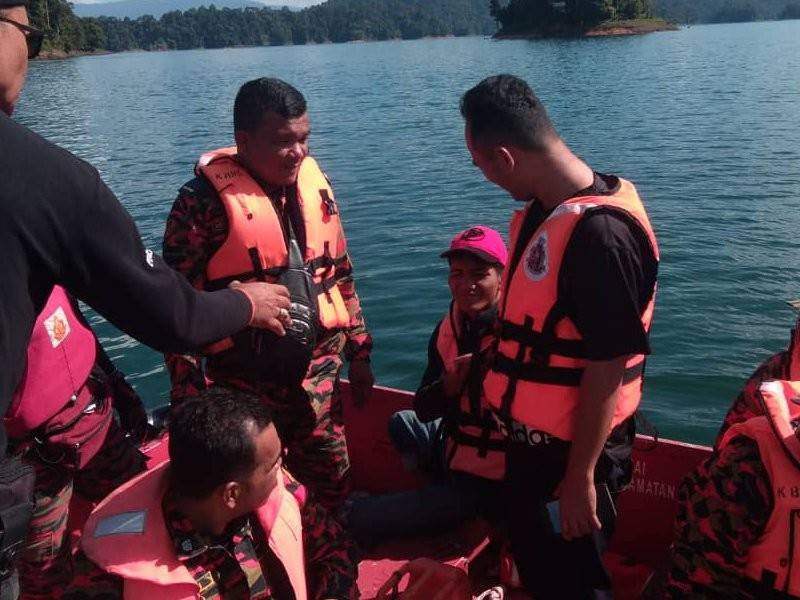 Mangsa (memakai topi) dilaporkan hilang di kawasan hutan Air Terjun Sungai Lasir, Tasik Kenyir dibawa keluar menaiki bot bomba setelah ditemui selamat kira-kira jam 3.25 petang tadi. - Foto Ihsan PDRM