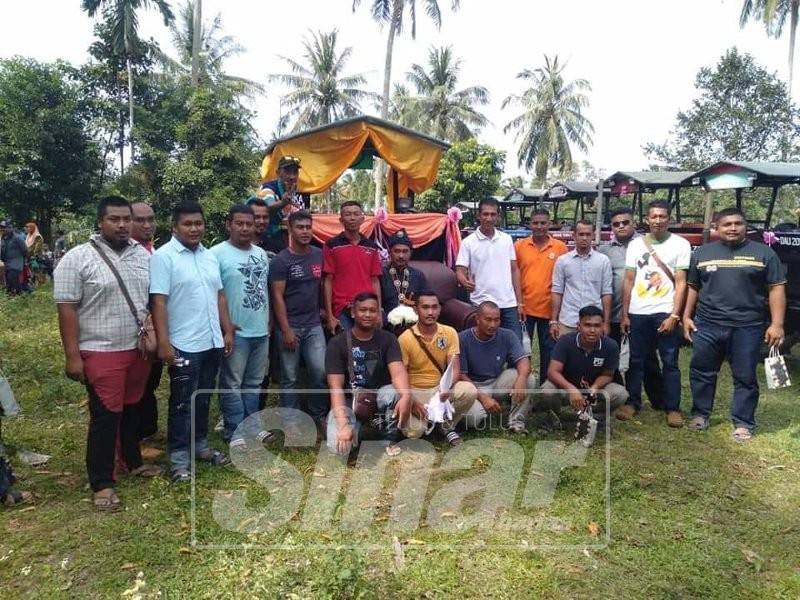 Mohd Jaimanajid (tengah) bersama keluarga dan rakan sebelum diarak dengan traktor ke rumah pasangannya.