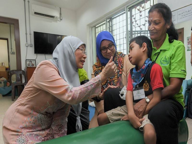 Timbalan Perdana Menteri Datuk Seri Dr Wan Azizah Wan Ismail bergurau senda dengan adik Muhammad Adam Wafiq Mohd Izwanie,8, (dua, kanan) yang ditemani ibunya Zuriana Zakaria,37, (tiga, kanan), selepas merasmikan Tasputra Perkim di Jalan Lingkungan U-Thant hari ini.- Foto Bernama