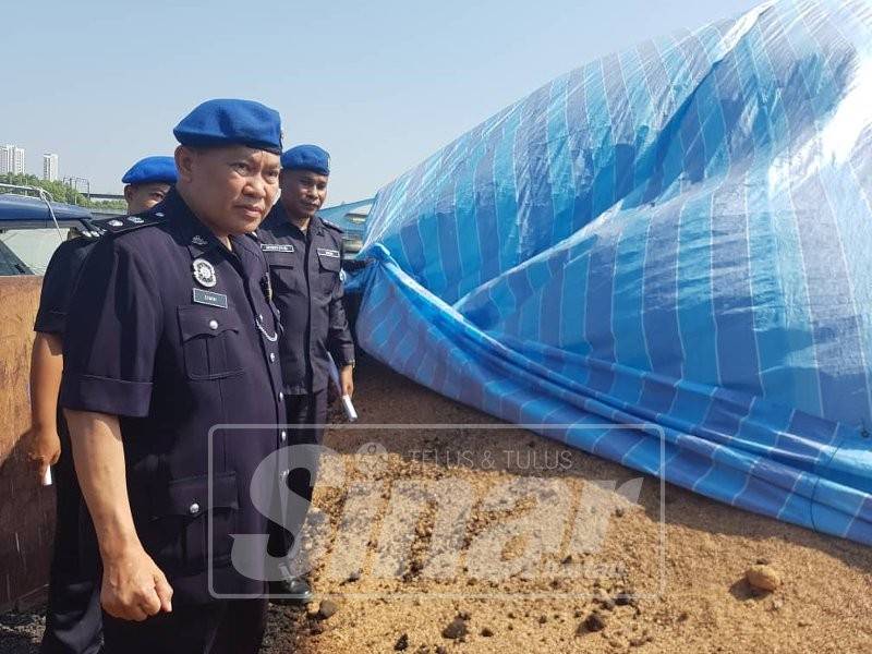 Dimin (kiri) menunjukkan tongkang yang membawa sisa kacang soya di Jeti Sungai Perai ketika sidang media tadi.