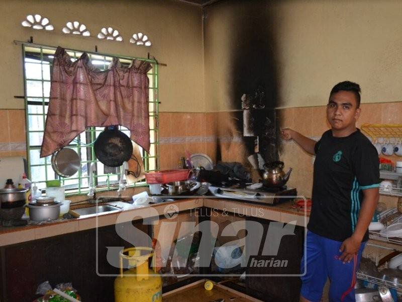 Muhammad Luqman menunjukkan keadaan dapur gas neneknya yang terbakar di Taman Bemban Damai, pagi tadi.
