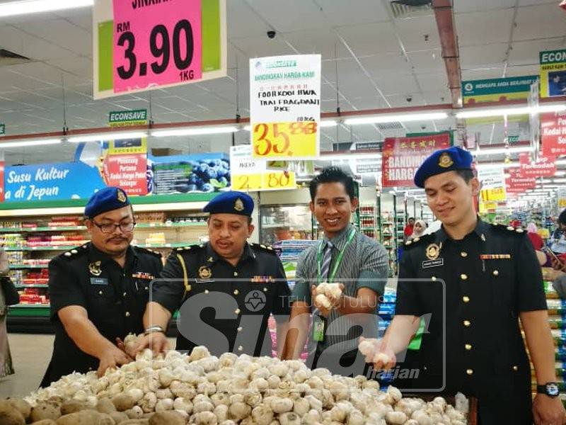 Mazlan (dua, kiri) memantau harga sempena Operasi dan Pemeriksaan Skim Kawalan Harga Tahun Baru Cina 2019 di sebuah pasar raya, hari ini.