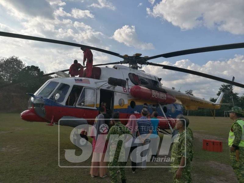 Orang ramai menunggu giliran untuk masuk ke dalam helikopter dan bergambar kenangan.