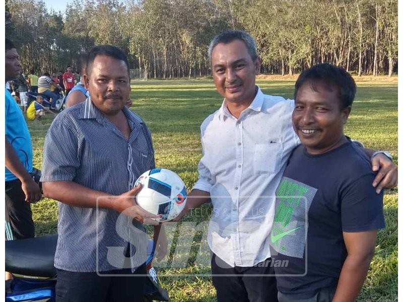 Mohd Fakaaruddin (tengah) bermesra dengan penduduk pada Pertandingan Bola Sepak dan Bola Jaring Tertutup Kuala Hau, di Temangan.
