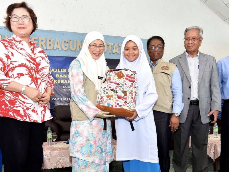 Timbalan Perdana Menteri Datuk Seri Dr Wan Azizah Wan Ismail (dua, kiri) menyampaikan bantuan beg sekolah kepada pelajar pada Majlis Penyerahan Wang Ihsan Bantuan Bencana Negara (Kebakaran) di Putatan dekat sini hari ini. Turut hadir Timbalan Ketua Menteri Sabah Datuk Christina Liew (kiri). - Foto Bernama