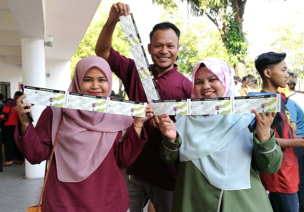 Mohd Zubir dan Noorhayati (bawah, kiri) mempamerkan tiket masing-masing.