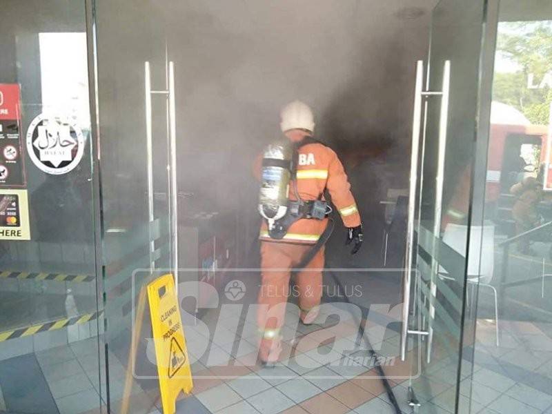 Anggota bomba ketika memadamkan kebakaran di restoran makanan segera di sini.