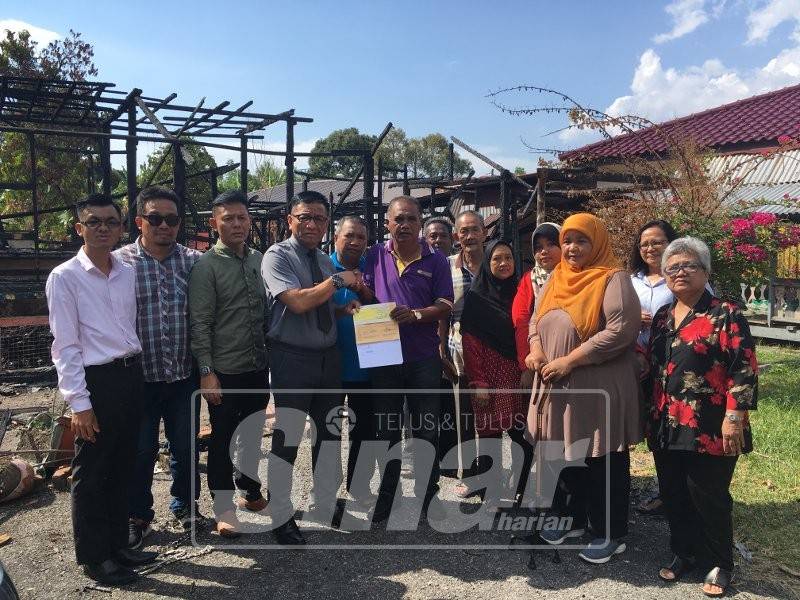 Norhizam menyerahkan wang Bantuan Khas Bencana Alam berjumlah RM3,000 kepada keluarga berkenaan di Bukit Peringgit.