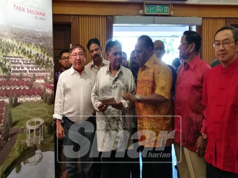 Samy Vellu (dua, kiri) mendengar penerangan daripada Saravanan pada majlis berkenaan.