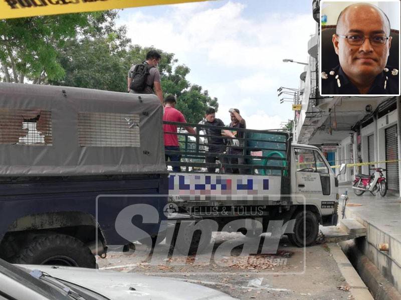 Anggota polis memeriksa mayat mangsa yang ditemui di belakang lori sebelum dibedah siasat di Hospital Raja Permaisuri Bainun, Ipoh.