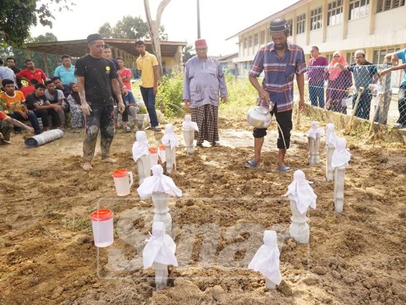 Salleh Tahir, 49, menyiram pusara isteri, anak, menantu dan cucunya yang maut dalam kemalangan di Pengkalan Atap, Batu Rakit awal pagi tadi.
