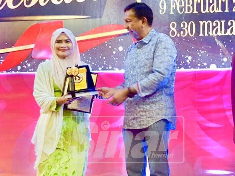 Zulkifli menyampaikan anugerah khas kepada wakil Sinar Harian, Nor Khalilah Gusti Hassan (kiri) pada majlis itu malam tadi.