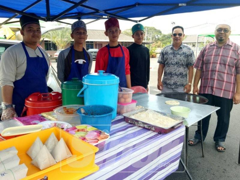 Mohd Noor (dua, kanan) dan Setiausaha masjid, Jamaludim Suaid bersama pelajar tahfiz yang membuka gerai di masjid berkenaan.