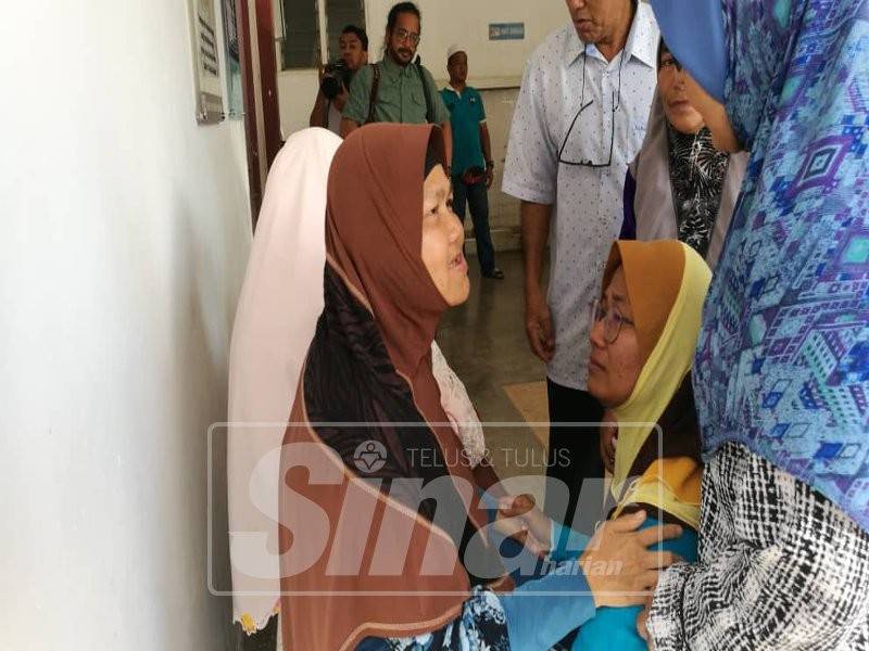 Nurdiana Alwani (kanan) meminta maaf kepada ibu arwah, Masitah di perkarangan Bilik Forensik HSNZ, pagi tadi.