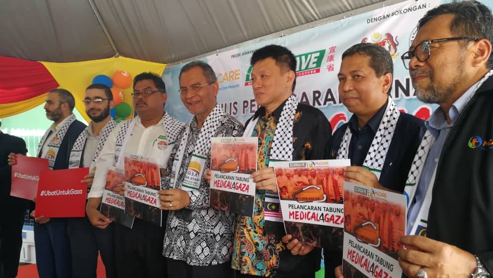 Dr Dzulkelfly (tengah) memegang plakad sebagai tanda sokongan misi kemanusiaan Medical4Gaza.