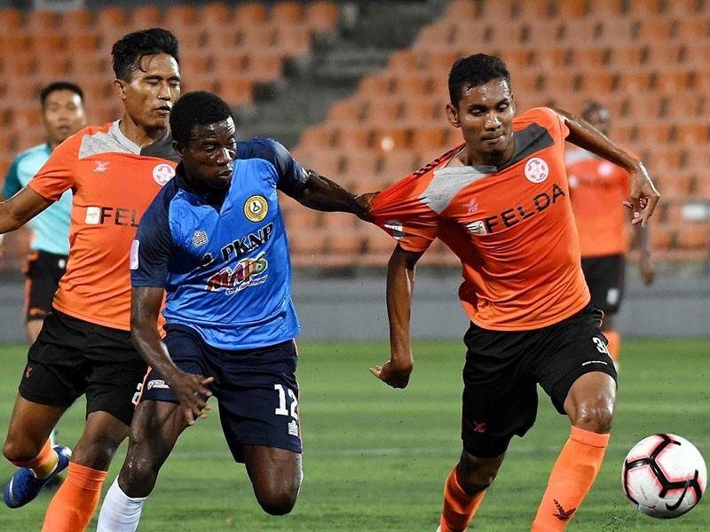 Pemain PKNP FC Thomas Abbey (tengah) dihalang pertahanan Felda United Ahmad Haziq Ahmad Puad (kanan) pada perlawanan Liga Super 2019 di Stadium Tun Abdul Razak, malam ini. - Foto Bernama