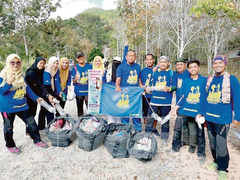 Norhalim (kanan) bersama ahli Kelab Seladang Hikers Jerantut bergotong-royong membersihkan kawasan Bukit Seladang.