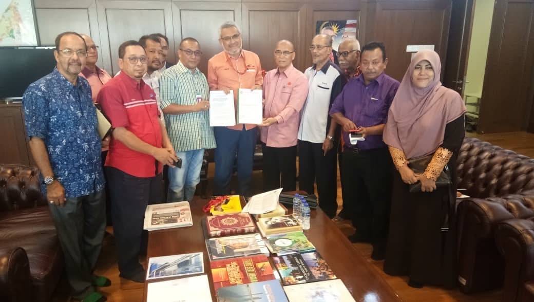 Rosli (kanan) menyerahkan memorandum berkaitan isu pemindahan tapak Bazar Ramadan Jalan Masjid India ketika pertemuan wakil-wakil persatuan penjaja dan peniaga bersama Khalid.