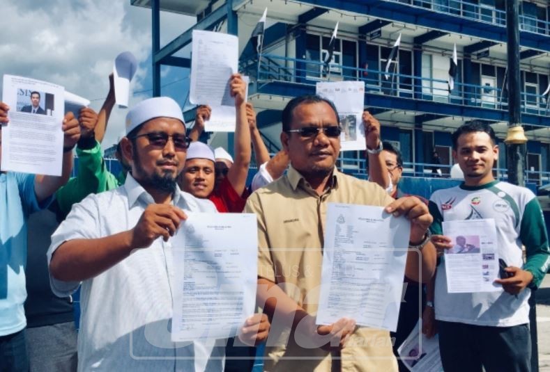 Mohd Zakhwan (kiri) bersama Andansura (kanan) dan ahli Pas menunjukkan laporan polis bagi mendesak dana asing yang didakwa diterima parti DAP di perkarangan IPD Kuantan, hari ini.