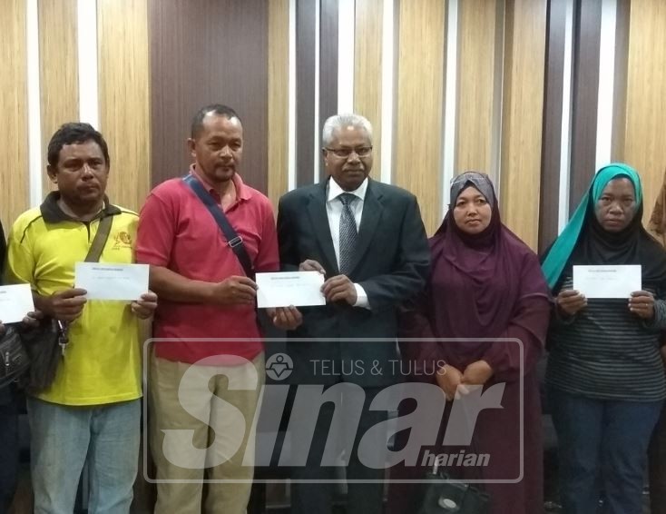 Sivanesan (tengah) menyerahkan sumbangan kepada waris mangsa kebakaran rumah kedai di Jelapang di Bangunan Perak Darul Ridzuan.