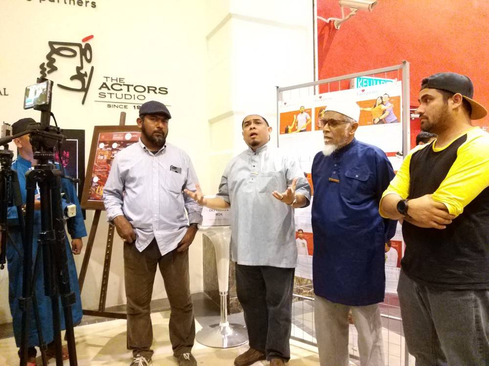 Mohamed Hafiz (tengah) bersama beberapa anggota NGO Islam lain berkumpul di hadapan Stage 2, Penangpac bagi membantah penayangan teater Love In Georgetown City tadi.